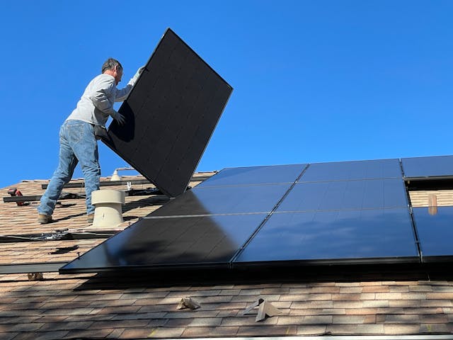 Mounting solar panels on a rooftop.