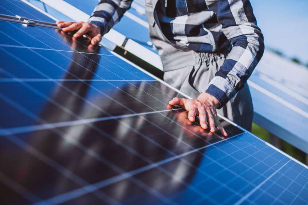 A technician inspecting solar panels on a rooftop.