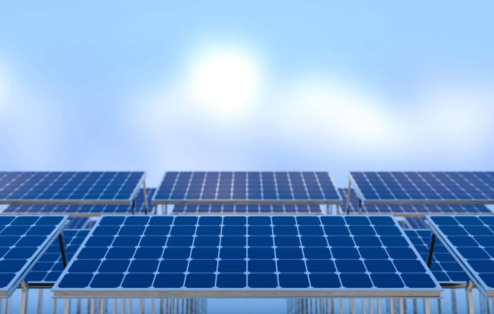 Solar panels arranged in rows under a clear blue sky.