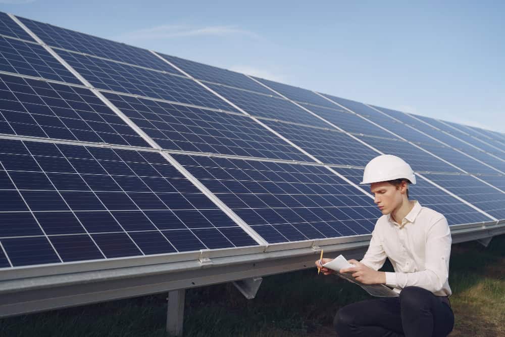 Solar panels being installed on a rooftop, with sunlight reflecting off them.