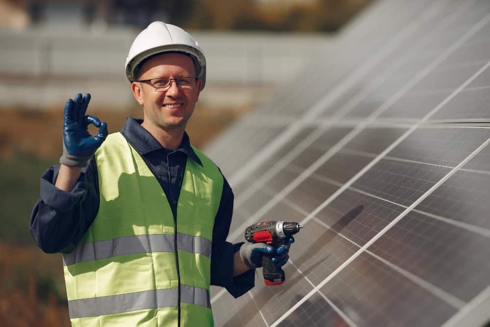 A man setting up solar panels on bright day.