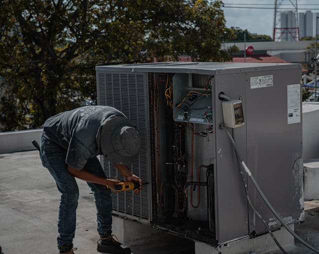 a man setting up hvac outside unit.