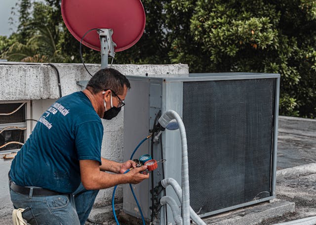 man setting up an hvac outside unit on a rooftop.